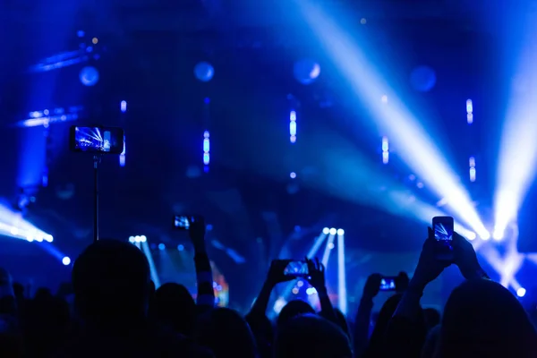 Silhouette di folle di spettatori a un concerto con gli smartphone in mano . — Foto Stock