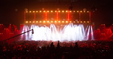 Konser kalabalık bir rock konserinde eğleniyor. Büyük konser salonu büyük bir sahne ile. Bir sürü insan. Yıldırım ekipman. Televizyon bir konser birkaç fotoğraf makinelerinde çekim.