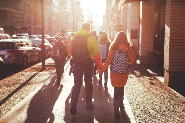 若い人たちのグループは 冬のベルリンの街を歩きます いくつかのカップルは 手を握り合います 明るい太陽の下でバックライトで撮影します 2018 — ストック写真