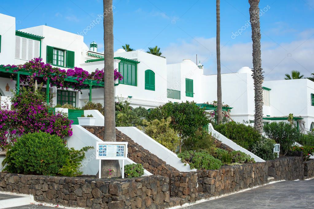 Beautiful white two-story houses for holidaymakers in Costa Teguise on Lanzarote island. Embankment near the ocean. Canary Islands.