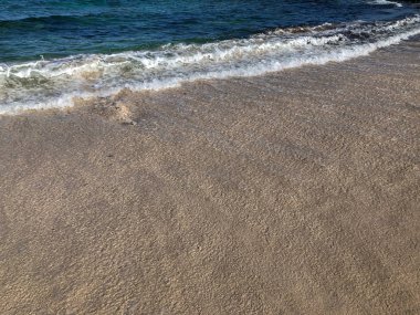 Yumuşak kum plajındaki mavi okyanus dalgası. Lanzarote Adası, İspanya.