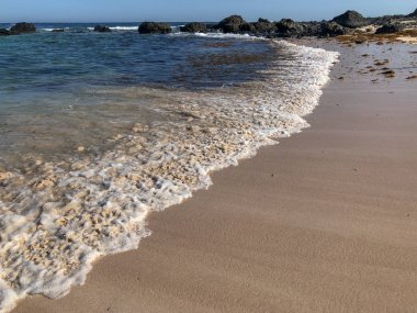 Yumuşak kum plajındaki mavi okyanus dalgası. Lanzarote Adası, İspanya.