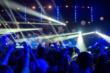 Kalabalık seyirci akıllı ellerinde bir konserde siluetleri.