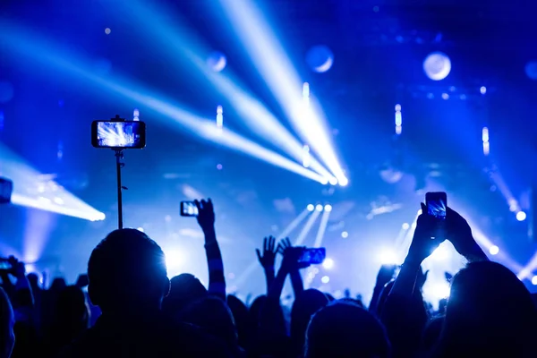 Silhouette di folle di spettatori a un concerto con gli smartphone in mano . — Foto Stock