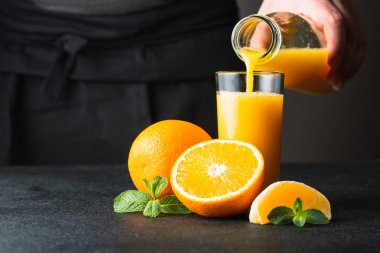 Bir cam içine portakal suyu dökme erkek el.