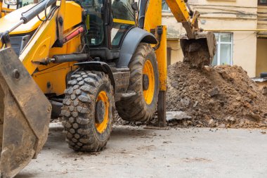 Ekskavatör ısıtma ana onarım çalışmaları için bir siper kazır.