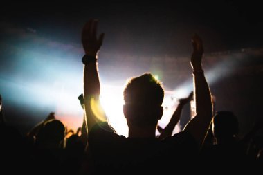 Bir konser kalabalığının silueti. Seyirci musicia alkışlıyor