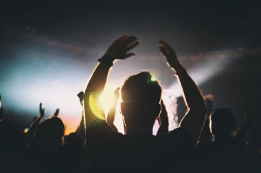 Parlak spot ışığı dans eden insanlar üzerinde parlıyor. Seyirci 