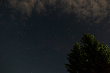 Parlak yıldızlar ve bulutlar ile gece gökyüzü.