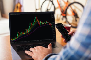 Bir işadamı ya da borsacı yeni yatırımlar için borsayı analiz etmek için evden çalışır. Kavram: Uzaktan çalışma evde.