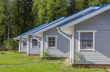 Güneş ışığı altında yeşil bir glade yaz evler