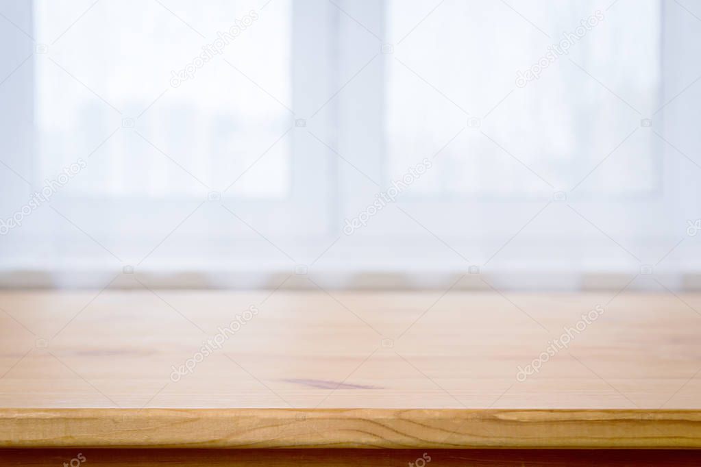 Wooden table surface on blurred white window background