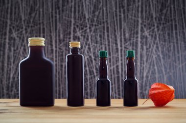 Dört koyu şişe ve physalis