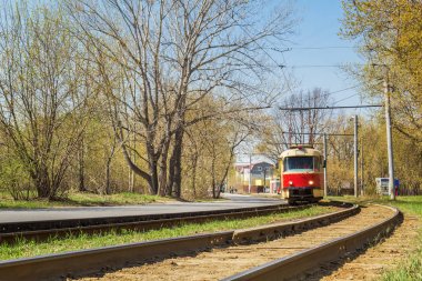 Tramvay rayları ve kırmızı tramvay mesafede
