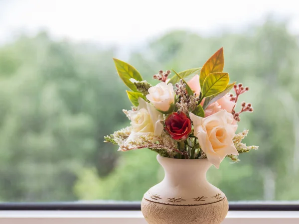 Vase of flowers on the background of an open window