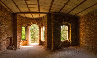 Güneş ışığında eski bir malikanenin pencereleri olan tuğla duvar