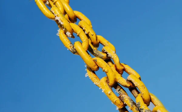 Old chain closeup on sky background.