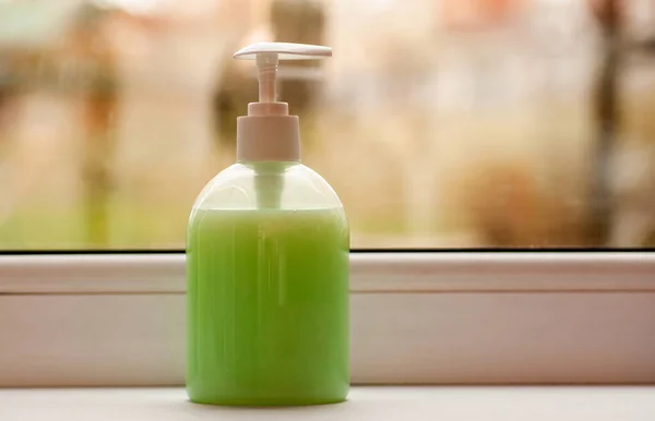 Una Botella Plástico Verde Con Detergente Está Pie Alféizar Ventana Imagen de archivo