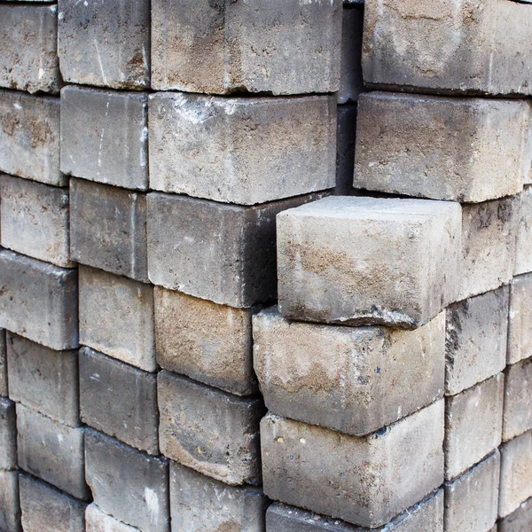 A number of packed concrete tiles close-up. Old concrete bricks stacked in a row.