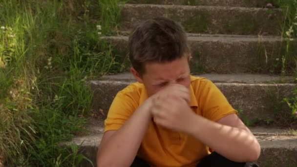 A fiú sír a lépcsőn ülve.. — Stock videók