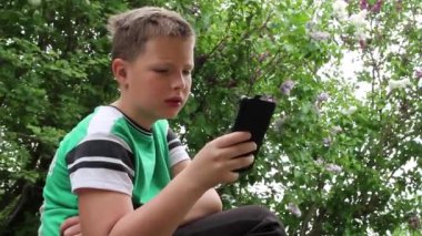 Üzgün çocuk akıllı telefon kullanıyor..