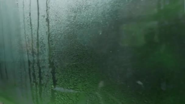 Мокрое стеклянное окно движущегося поезда. — стоковое видео