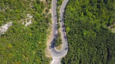 Bir yılan gibi dağ yolda havadan görünümü araçların hareketi. Hırvatistan. Üstten görünüm