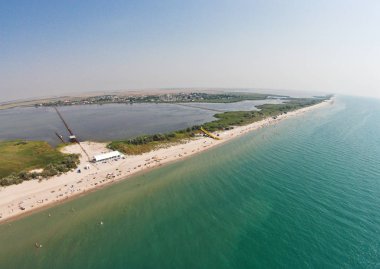 Bir plaj sahil şeridine ve deniz metalik bridge ile havadan görünümü.