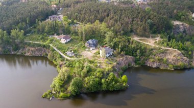 Ağaç ve ev kıyısında küçük bir nehrin havadan görünümü.