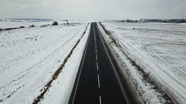 冬の道と雪に覆われたフィールドの空撮 — ストック動画