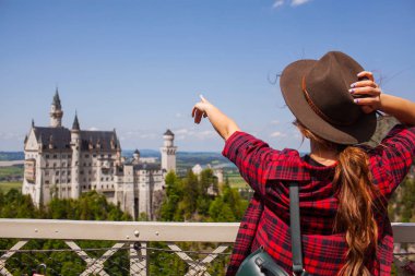 Şapkalı Kız yandan Castle Neuschwanstein Alp dağ tarafından gösterir