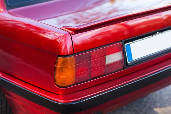 De achterkant van een rode retro auto met een kleine vleugel — Stockfoto