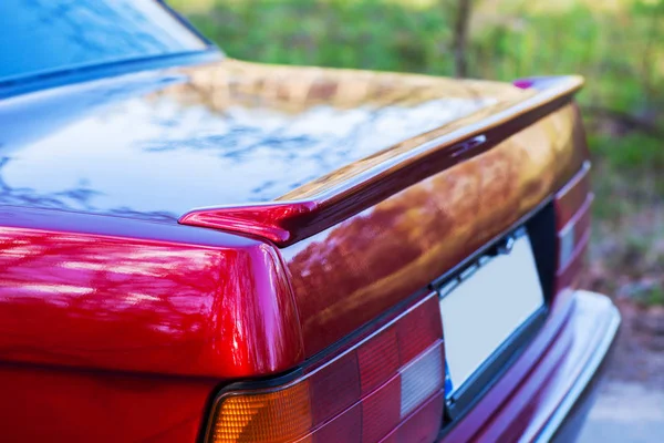 De achterkant van een rode retro auto met een kleine vleugel — Stockfoto