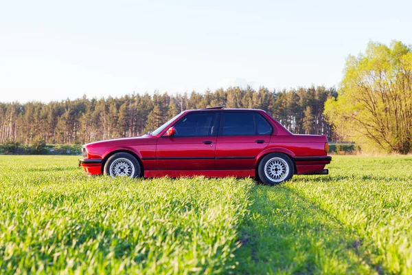 Face avant gauche d'une vieille voiture allemande qui se tient sur l'herbe verte au coucher du soleil — Photo