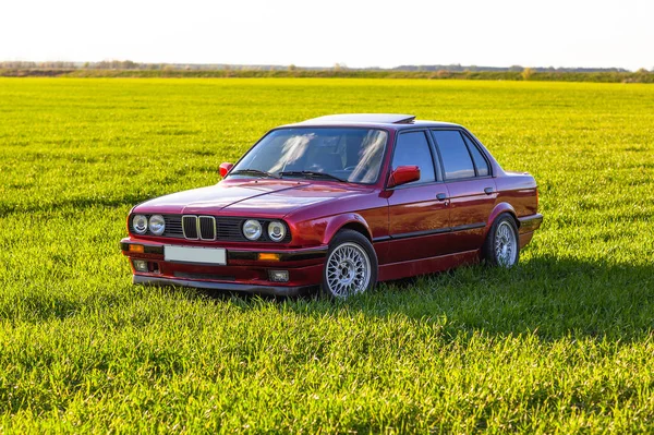 Vordere linke Seite eines alten deutschen Autos, das bei Sonnenuntergang auf grünem Gras steht — Stockfoto