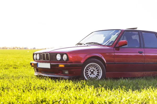 Vordere linke Seite eines alten deutschen Autos, das bei Sonnenuntergang auf grünem Gras steht — Stockfoto