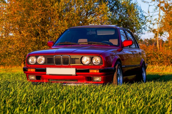 Face avant d'une vieille voiture allemande qui se tient sur l'herbe verte au coucher du soleil — Photo