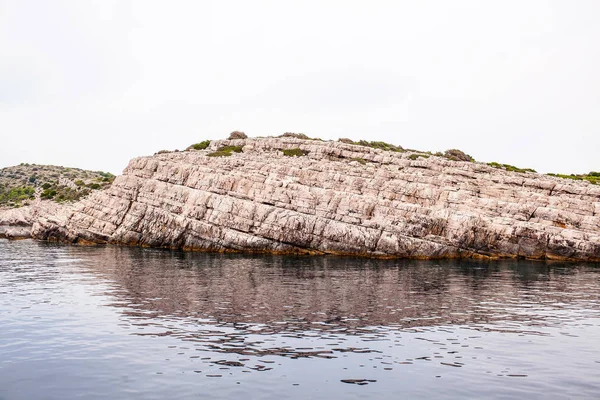 Uma grande parede de pedra de pedra bege no mar — Fotografia de Stock