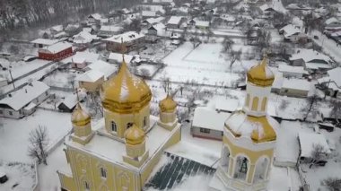 Kışın, Ukrayna 'nın küçük bir kasabasında kar yağışı sırasında bir kilisenin havadan görünüşü