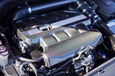 Karbon elementlerden oluşan motor bir spor arabaya yaklaşır..