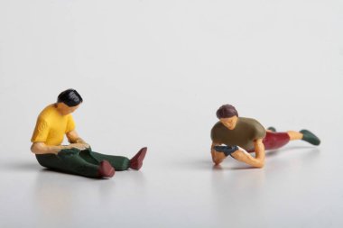 minyatür figürler insanların bir gazete ya da bir kitap okuma