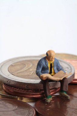 insanlar Minyatürler dev 2 euro sikke üzerinde bir gazete okuyor