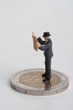 insanlar Minyatürler dev 2 euro sikke üzerinde bir gazete okuyor