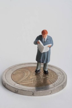 insanlar Minyatürler dev 2 euro sikke üzerinde bir gazete okuyor