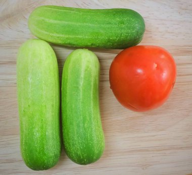 Sebze, taze Ripe domates salatalık ahşap kesme tahtası ile.