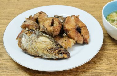 Geleneksel Delicuous Deep Fried yılanbaşı balık baharatlı, tuzlu ve ekşi sos, yüksek Protein, B12 vitamini, niasin veya B3 ve Omega-3, temel besin ile ömür boyu servis beyaz bir plaka üzerinde çizgili.