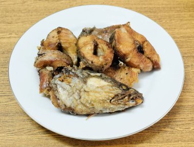 Geleneksel Delicuous Deep Fried yılanbaşı balık beyaz tabakta yüksek Protein, B12 vitamini, niasin veya B3 ve Omega-3, temel besin yaşam için çizgili.