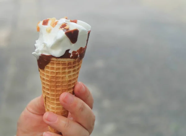 Mão Segurando Sorvete Baunilha Com Chocolate Noz Cone Waffle — Fotografia de Stock