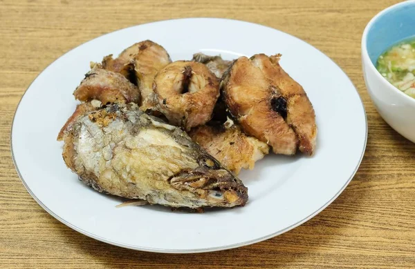 Geleneksel Delicuous Deep Fried yılanbaşı balık baharatlı, tuzlu ve ekşi sos, yüksek Protein, B12 vitamini, niasin veya B3 ve Omega-3, temel besin ile ömür boyu servis beyaz bir plaka üzerinde çizgili.
