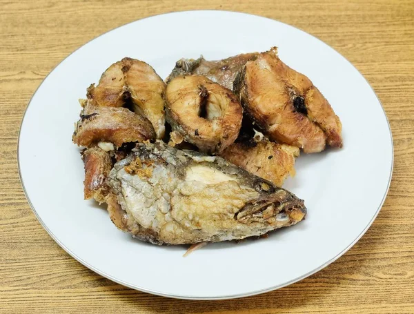 Geleneksel Delicuous Deep Fried yılanbaşı balık beyaz tabakta yüksek Protein, B12 vitamini, niasin veya B3 ve Omega-3, temel besin yaşam için çizgili.